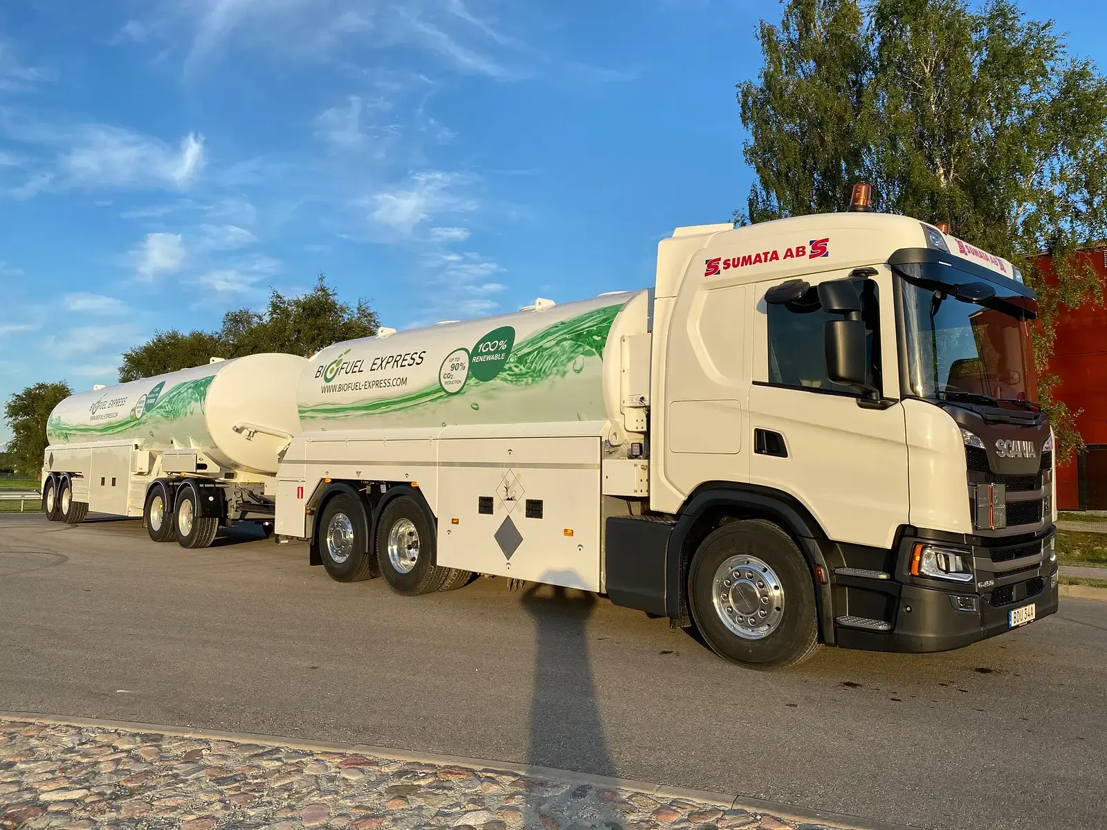 Vit Scania-tankbil med släp märkt Biofuel Express
