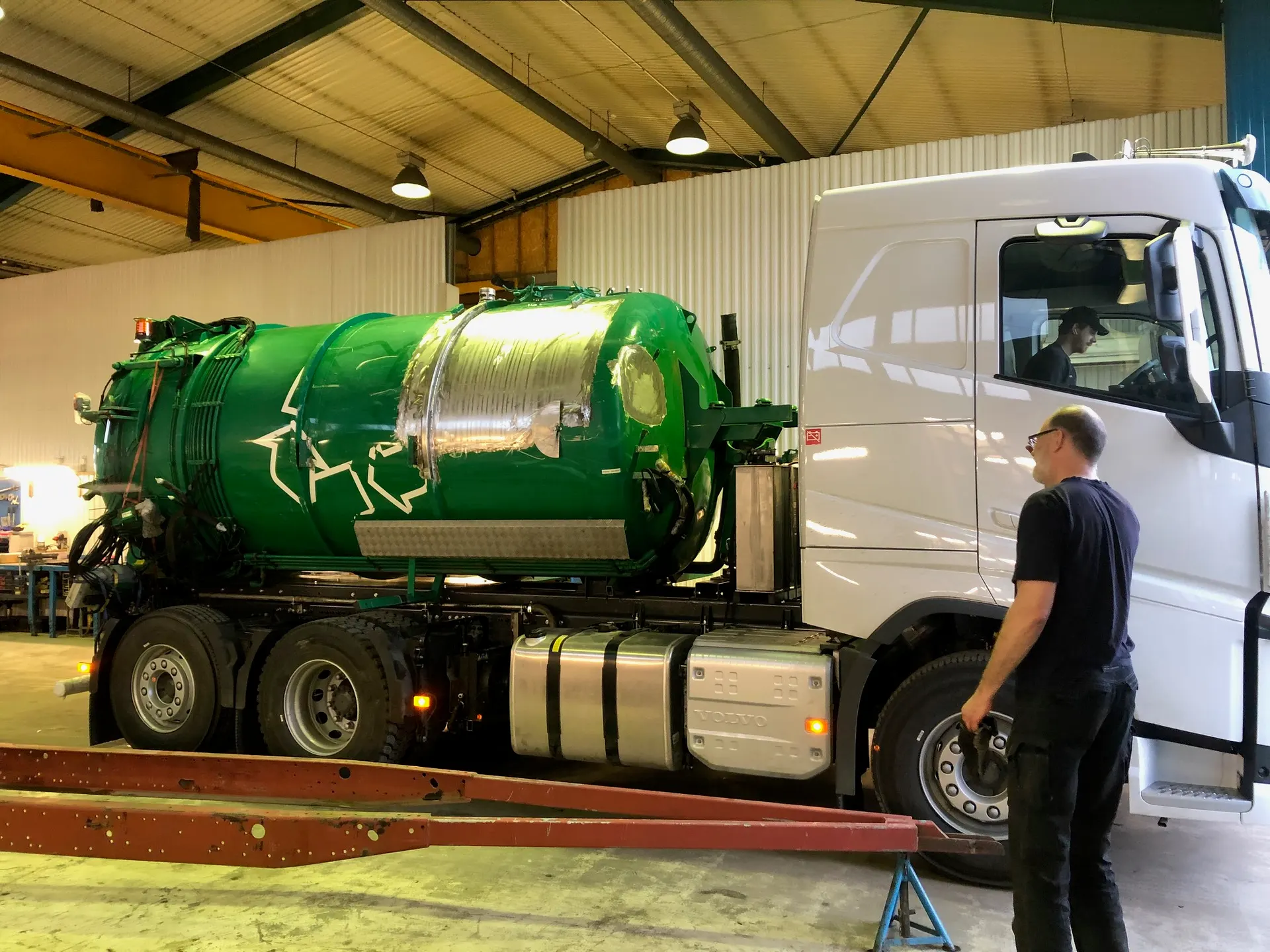 Före: Volvo-slambil med grön tank i verkstaden