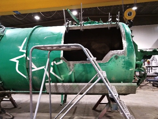Före: grön tank med öppen lucka i verkstadshallen
